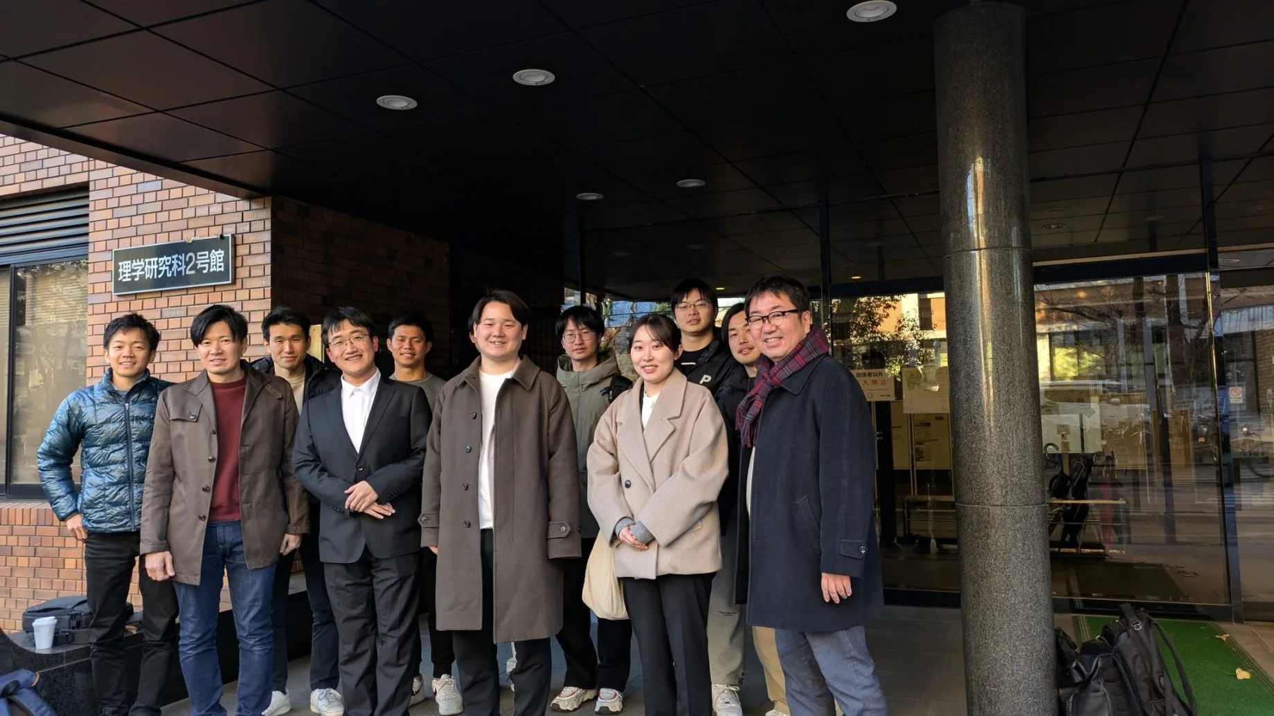 A group poses outside Kyoto University’s Graduate School of Science Building No. 2 after the master’s thesis presentations and Q&A.